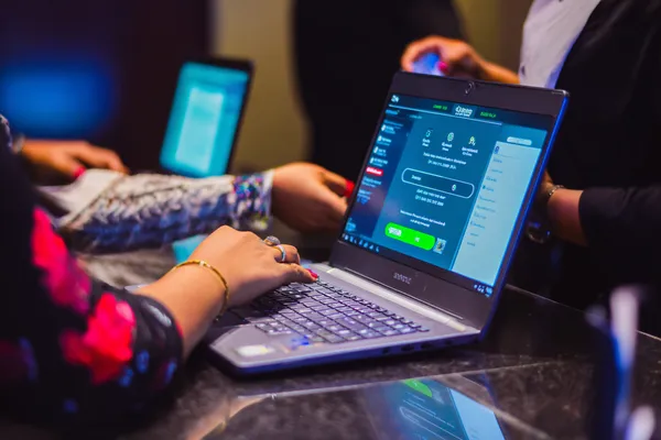 A confident dealer surrounded by casino chips inviting players to access their LEGIONBED account, reflecting quick and easy login options.